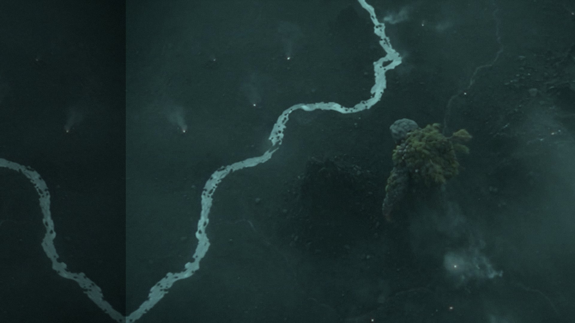 Aerial shot from Gods Versus Monsters: a moss-covered titan crosses a dark valley beside a glowing river